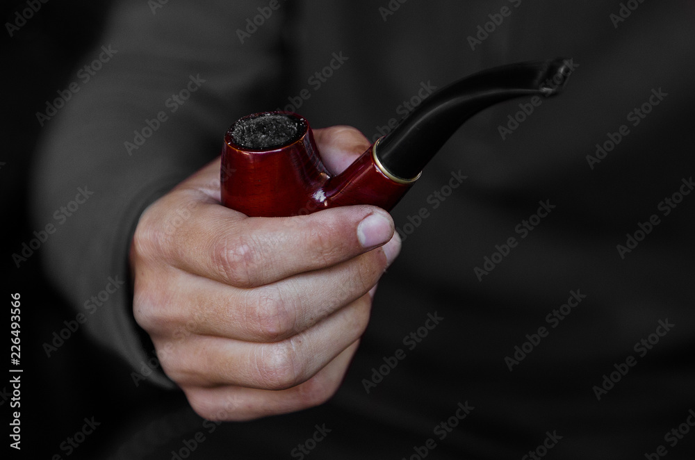 male hand holding a wooden smoking pipe Stock Photo