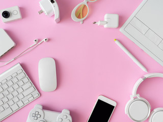 Poster - top view of office desk workspace with smartphone, notebook, graphic tablet, keyboard and mouse on pink color background, graphic designer, Creative Designer concept.