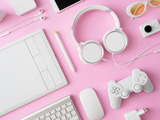 Poster - top view of office desk workspace with smartphone, notebook, graphic tablet, keyboard and mouse on pink color background, graphic designer, Creative Designer concept.