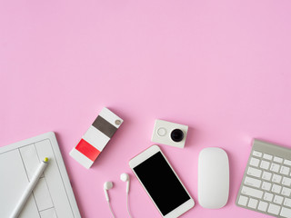 Poster - top view of office desk workspace with smartphone, notebook, graphic tablet, keyboard and mouse on pink color background, graphic designer, Creative Designer concept.