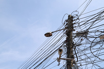 Coseup of old electricity pole, wire, lamp, cctv. and other things.