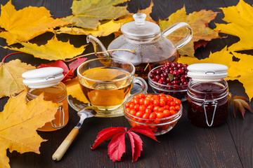 Wall Mural - healthy background. Wild berry and  raspberry jam, honey and tea on fall wooden table