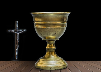 Wall Mural - Old chalice on wooden table next to an iron Cross