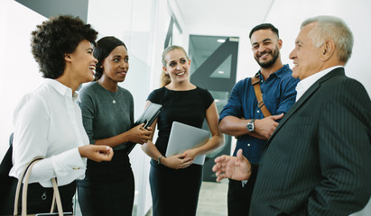 Multi-ethnic business group in office corridor