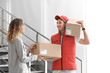 © New Africa - Young woman receiving parcel from courier indoors