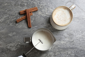 Sticker - Milk frother over pitcher near cup of coffee and cinnamon sticks on table