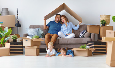 happy family mother father and children move to new apartment and unpack boxes