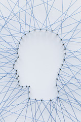 Poster - Human head shape made from a large grid of pins connected with string. Communication technology and mental health concept