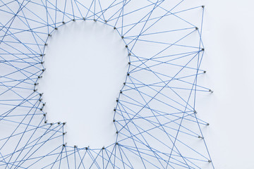 Poster - Human head shape made from a large grid of pins connected with string. Communication technology and mental health concept