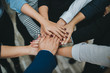 © Sondem - Group of business people team joining hands together in office.