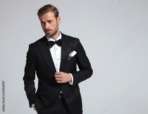 Valokuva  sexy elegant man wearing tuxedo and bowtie posing