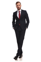 Canvas Print - relaxed businessman standing with hands in pockets and legs crossed