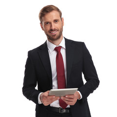 Wall Mural - portrait of smiling unshaved businessman holing a tablet