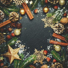 Christmas or New Year dark background, frame, template, with festive decorations, winter spices and Christmas decorations, nuts and fir branches, top view