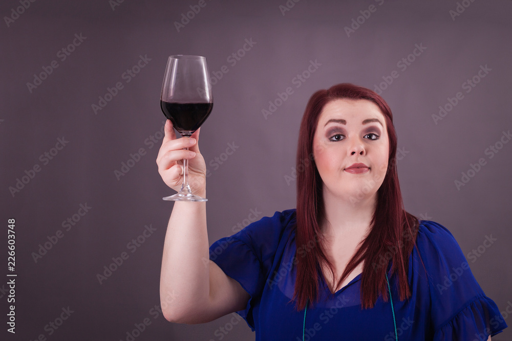 Young female woman holding up a glass of red wine to give a proper toast in  celebration Stock Photo | Adobe Stock