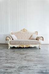 beautiful expensive beige sofa against a white wall in an empty room