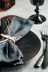 Wall Mural - Festive table setting in a black style among black candles.  Close-up. Thanksgiving or Halloween dinner.