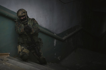 A army soldier takes aim with a pistol gun in his hands. Storming the building concept.