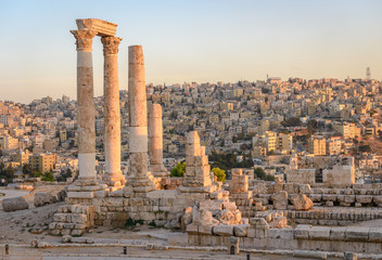 Wall Mural - Amman, Jordan its Roman ruins in the middle of the ancient citadel park in the center of the city. Sunset on Skyline of Amman and old town of the city with nice view over historic capital of Jordan.