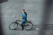 © LIGHTFIELD STUDIOS - high angle view of businessman in formal wear sitting on bike and checking wristwatch