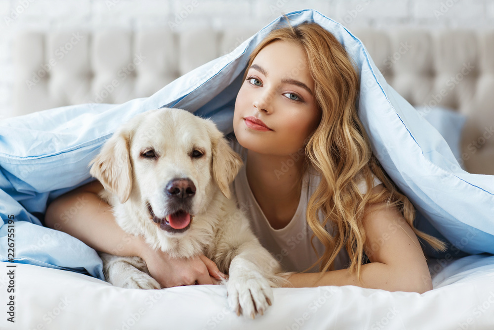 Beautiful teen girl with golden retriever dog in a bed Stock Photo ...