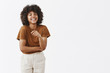 © Cookie Studio - Studio shot of cute african american woman with afro hairstyle in trendy summer outfit having fun laughing out loud from joy and funny joke gesturing with palm chuckling and smiling carefree at camera