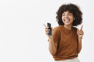 Wall Mural - active energetic and happy young african american female dancer in brown t-shirt listening music in 