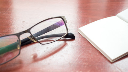 Wall Mural - glasses and notebook on wood table