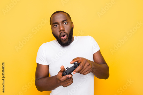 Photo  Portrait of shocked funny funky crazy mulato man, playing online