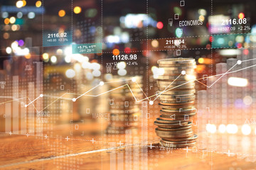 Double explosure with businesss charts of graph and rows of coins for finance at night city background.