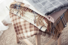 Blankets Close Up. Autumn Cozy Interior. A Stack Of Warm Blankets Lie On A Wooden Chair. Autumn. Winter.