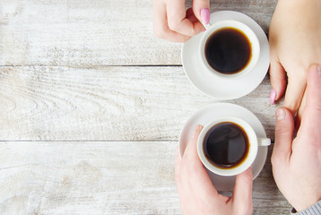 Wall Mural - Cups with a coffee in the hands of men and women. Selective focus.