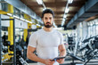 © dusanpetkovic1 - picture of strong handsome personal fitness trainer posing in front of the camera in bright gym.