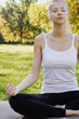 © Olesia - Girl meditates while practicing yoga outdoors in park