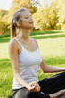 © Olesia - Girl meditates while practicing yoga outdoors in park