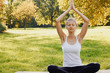© Olesia - Girl meditates while practicing yoga outdoors in park