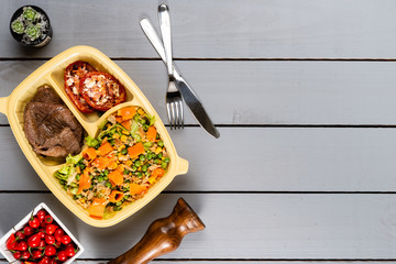 Meat and tomato stuffed with salad. Brazilian lunch box. Ahead meal preparation or dieting concept. top view.