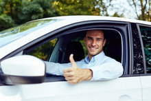 A Young Man Sitting In A Car Showing Thumb Up