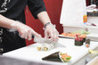 Cocinero cortando rollos de sushi