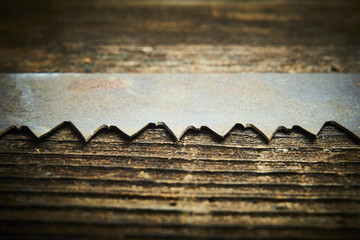 Wall Mural - Close up of an old and rusty antique handsaw om wooden desk. Selective focus