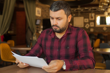 Wall Mural - Worried man looking at papers