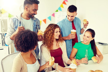 Canvas Print - corporate, celebration and people concept - happy friends or team eating sandwiches with coffee and non-alcoholic drinks at office party