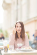 © bokan - Young beautiful woman sitting in a cafe outdoors,eating salad and posing for a camera