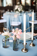 Wedding decor. Two cadles and two small bouquets in glass jars