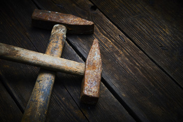 Wall Mural - Close up of two old used hammer on a rustic wooden background. Selective focus