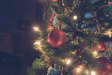 Retro Image Of Shiny Red Christmas Bauble Hanging On Tree