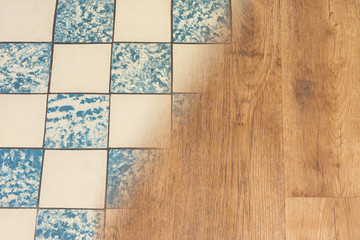 Retro ceramic tiles and modern vinyl floor. Housing renovation concept. Contrast of old worn tile facing and new wooden flooring texture. Split background. Interior reconstruction and modernization.