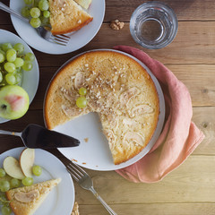 Wall Mural - Freshly baked apple pie rustic, dark wood background. Autumn fruits: grapes, apples, nuts. Still life dessert homemade food, square image, top view.