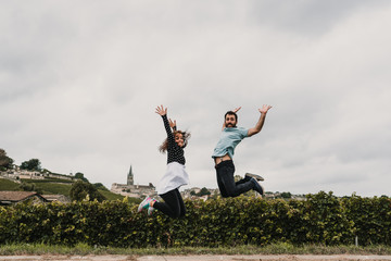 .Young couple in love, touring the vineyards of France at the time of grape harvest. Having fun taking pictures while jumping. Lifestyle