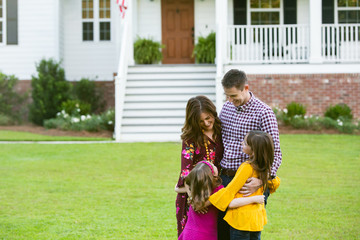 Wall Mural - Family of Four hugging Outside their New Construction Home Farm House